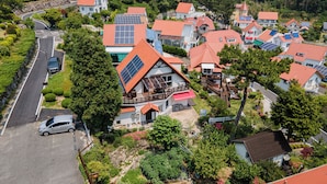 Een woonwijk met huizen met rode dakpannen en zonnepanelen.