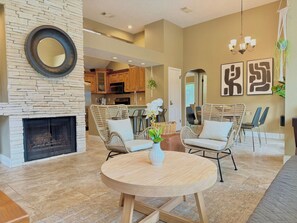 A modern living room with a fireplace, wicker furniture, and a round wooden table. - Beautiful 2BR Home near to Houston TX (Katy)