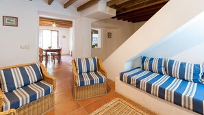 A cozy living area with wicker sofas and a dining table. - Family apartment Ca l'Amo (Sineu)