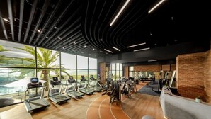 Ein modernes Fitnessstudio mit Laufbändern, Kraftgeräten und einem großen Fenster mit Blick auf eine schöne Landschaft.