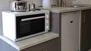 A compact kitchen with a built-in oven, a kettle, and a sink. - Elena Rooms (Agios Vasileios)