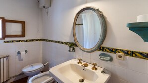 Un baño con inodoro, lavabo y espejo.