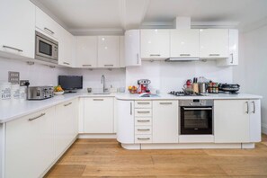 Enjoy cooking in this well-equipped kitchen with stainless steel oven, microwave, and a variety of appliances.