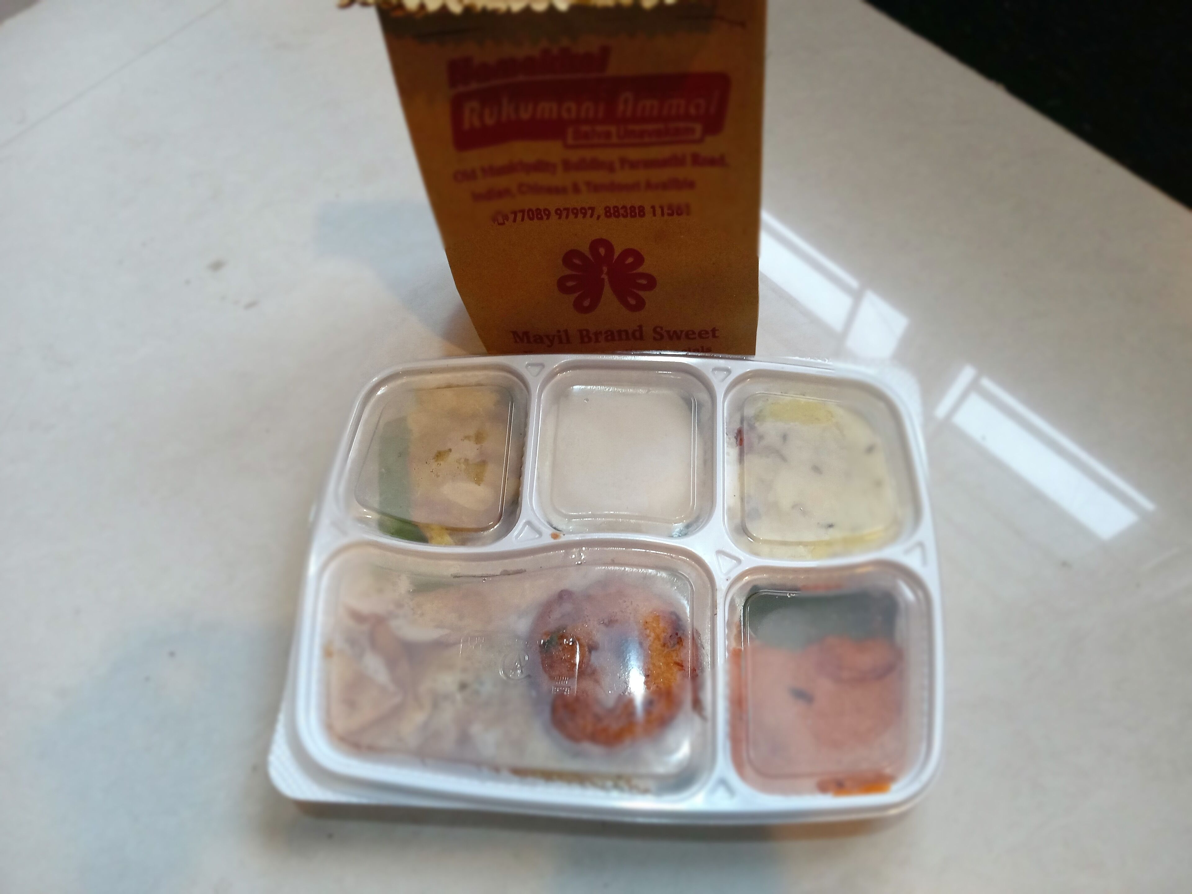 Un recipiente para comida con cuatro divisiones que contienen distintos alimentos.