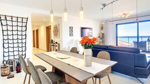 Un comedor moderno con una mesa larga, sillas e lámparas colgantes.