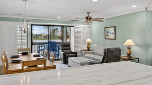 A dining area with a wooden table and chairs, a sofa, and a ceiling fan. - Beautiful Gulf & Lake Views | Easy Walk to the Beach and Pool (Miramar Beach)