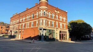 A red brick building with a dome and arched windows, likely a historic building with a central entrance and a fire hydrant in front. - 115#202 / Charming Downtown Dubuque Apartment (Dubuque)
