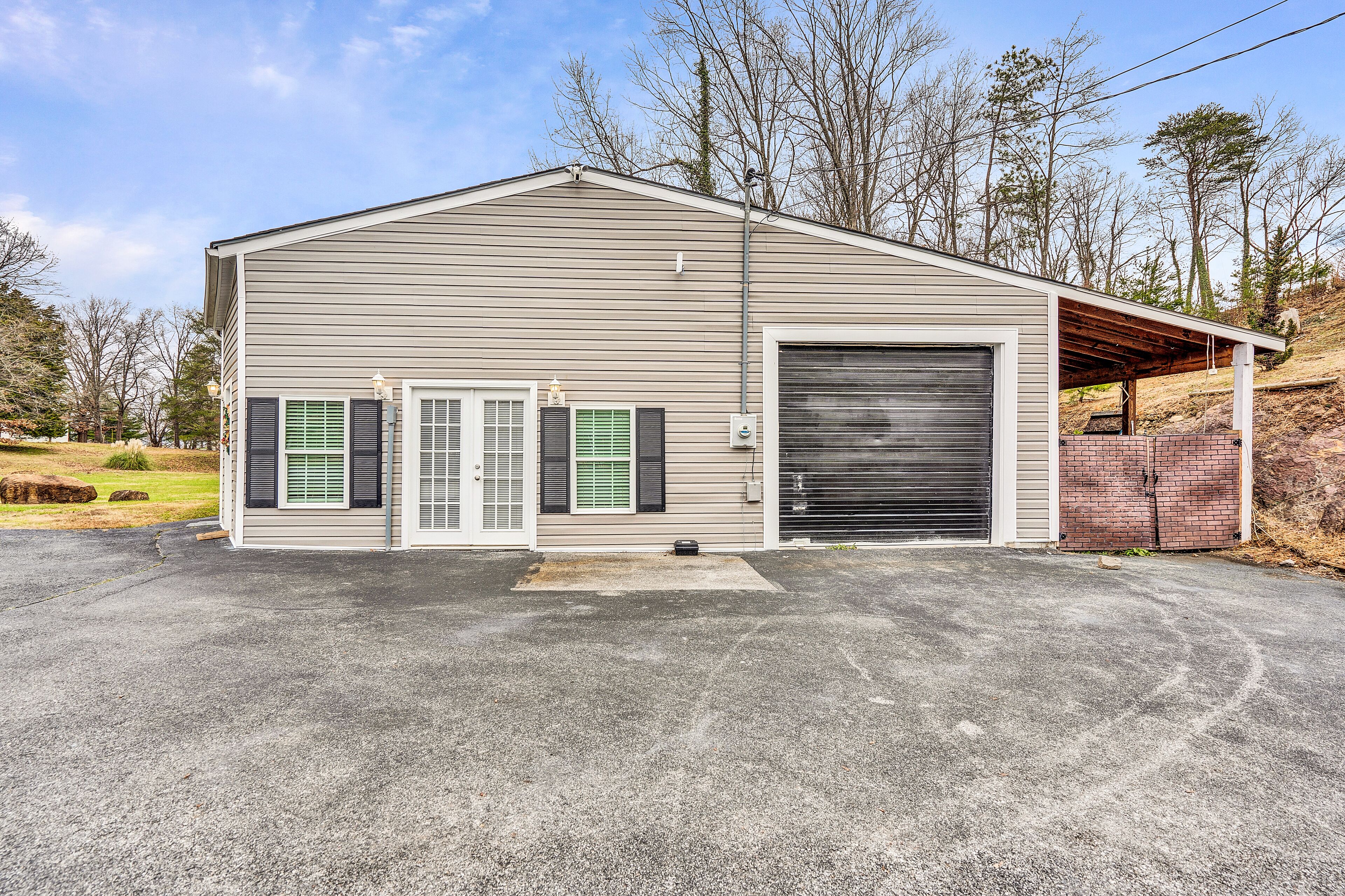 A single-story building with a large garage door, a covered entryway, and a small porch.