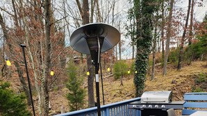 An outdoor deck with a fire pit, a grill, and a blue patterned rug. - Beautiful Renovated Lake Cottage in SW County and only minutes from Downtown! (Roanoke)
