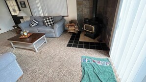 Una sala acogedora con sofá, una mesita de centro y chimenea.