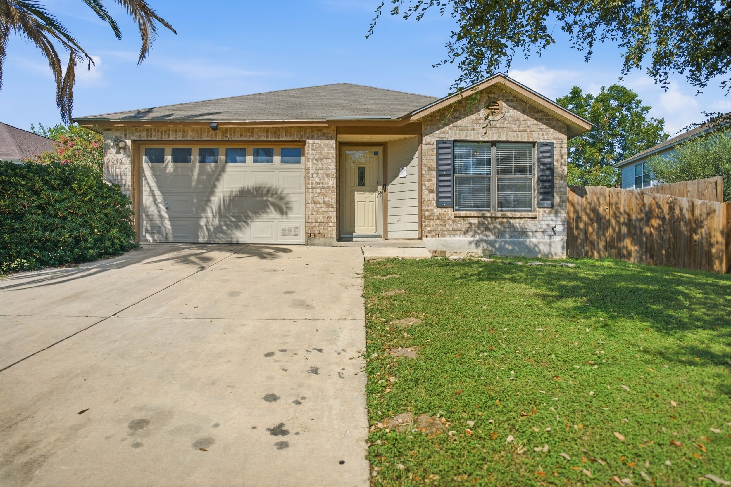 A residential house with a garage, a front door, and a small front yard.