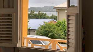 A view from a balcony with a railing, overlooking a body of water, boats, and buildings. - Bright house overlooking the bay of Marin (LE MARIN)
