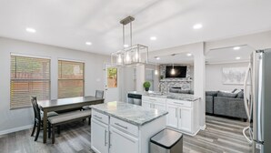 A modern kitchen with white cabinetry, a granite countertop, and stainless steel appliances. - Beautiful and Spacious, Home - Great location! (San Antonio)