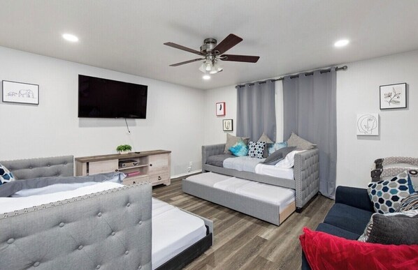 A modern bedroom with a bed, a sofa, a desk, and a ceiling fan. - Beautiful and Spacious, Home - Great location! (San Antonio)
