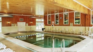 An indoor swimming pool with a wooden ceiling, clear glass walls, and a tiled floor. - Warm and inviting, close to the best New England hiking and outdoor fun! (Bartlett)