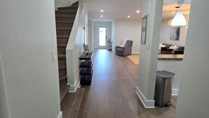 A spacious hallway with wooden flooring, white walls, and a staircase leading to another level. - Luxurious & Spacious Townhouse in Prime Location (Miami)