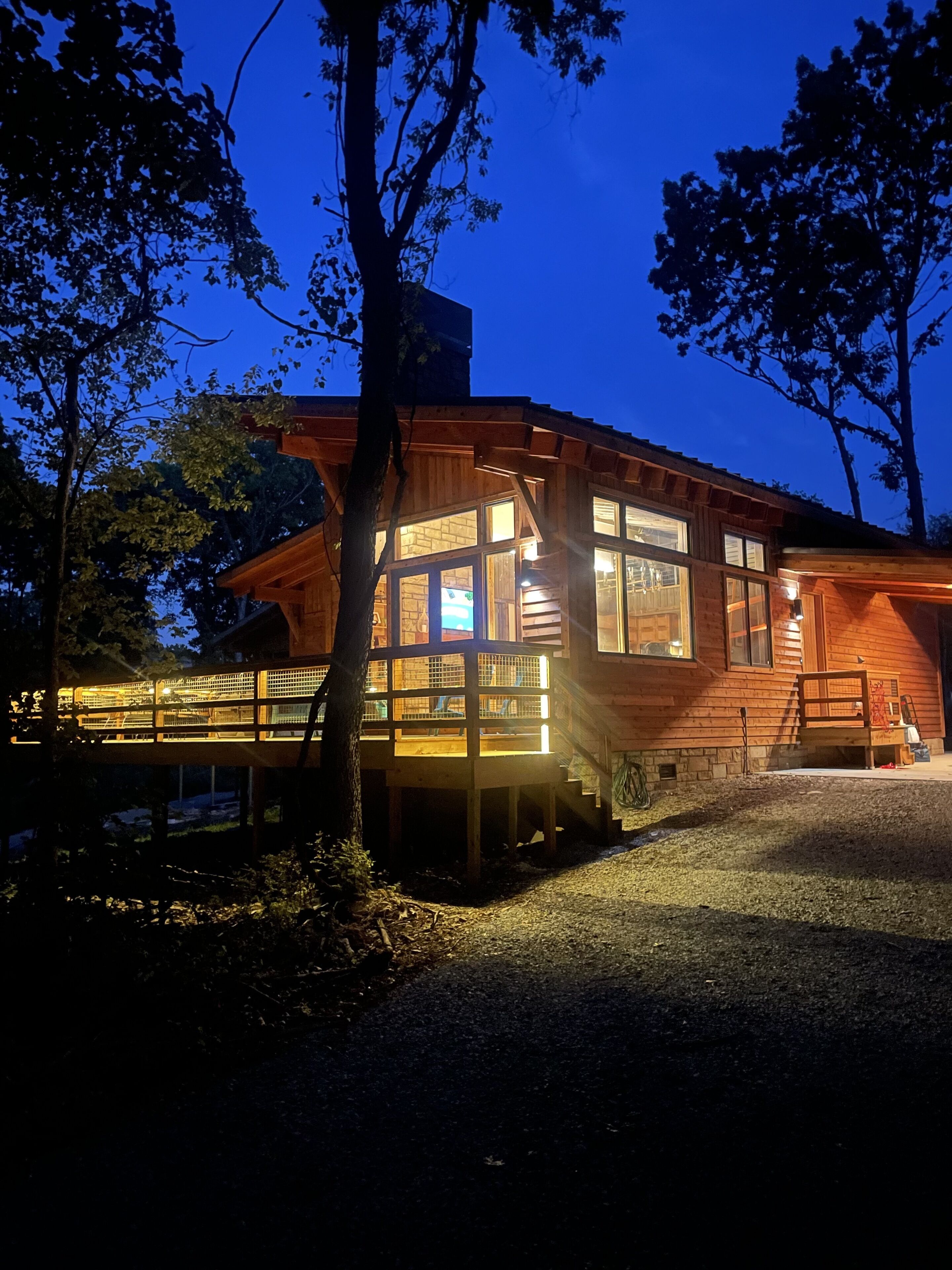 Une cabane en bois dotée d’une terrasse couverte et d’un escalier menant à l’entrée.