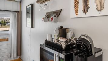 A compact kitchenette with a microwave, coffee maker, and a small dining area.