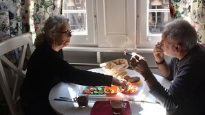 A dining table with a meal, a window with curtains, and a view of buildings outside. - columbia sky city (Cairo)