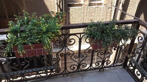 A balcony with wrought iron railings and potted plants. - columbia sky city (Cairo)
