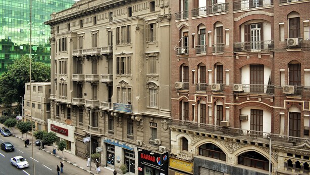 A multi-story building with a classic architectural style, featuring balconies and large windows. - columbia sky city (Cairo)