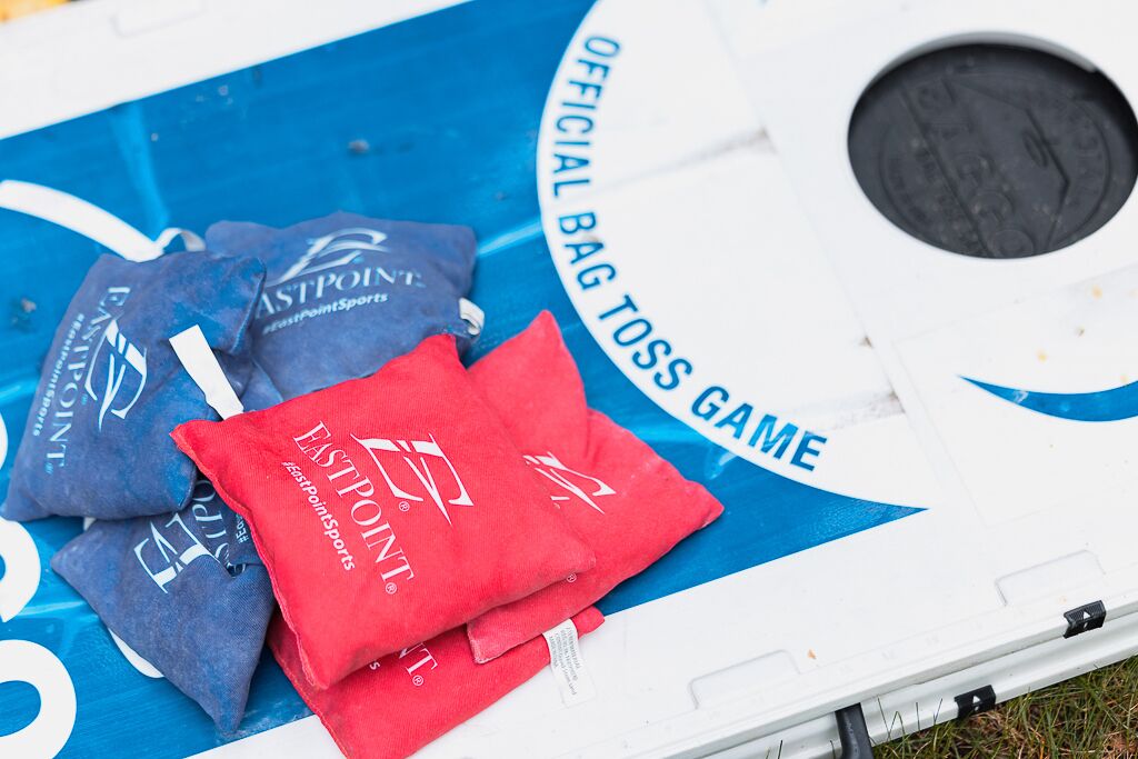 A blue and white bag toss game with red and blue bags labeled "FastPoint Sports".