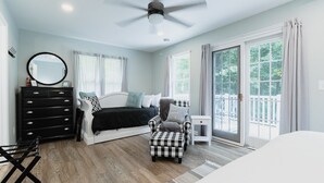 Ein Schlafzimmer mit Bett, Kommode, Stuhl und Fenster.