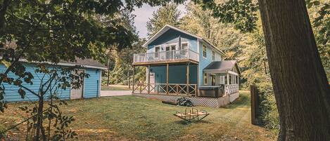 A two-story house with a balcony, a fenced yard, and a swing set.