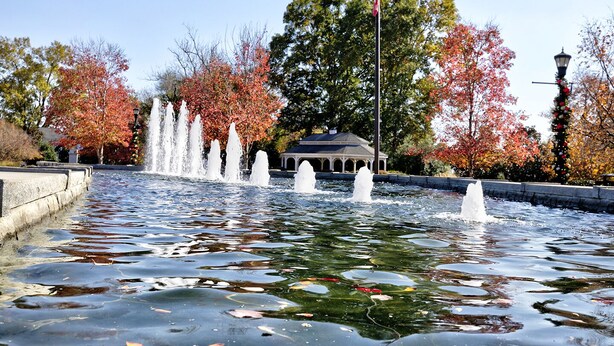 A fountain with multiple jets of water, surrounded by trees with autumn foliage. - Charming Country Cottage Retreat -  Walking distance to Downtown (Dallas)