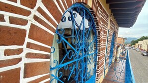 A brick wall with a decorative metal gate and a tiled floor.