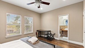 A bedroom with a bed, a desk, and a ceiling fan. - 🏝️LUX Hot Tub +Chiller Near DT: Spa Baths, Yard Games, Arcade, Parking, SLEEPS 18 (Austin)