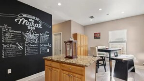 A modern kitchen with a black backsplash featuring a welcome sign and lists of top restaurants, bars, and brunches. - 🏝️LUX Hot Tub +Chiller Near DT: Spa Baths, Yard Games, Arcade, Parking, SLEEPS 18 (Austin)