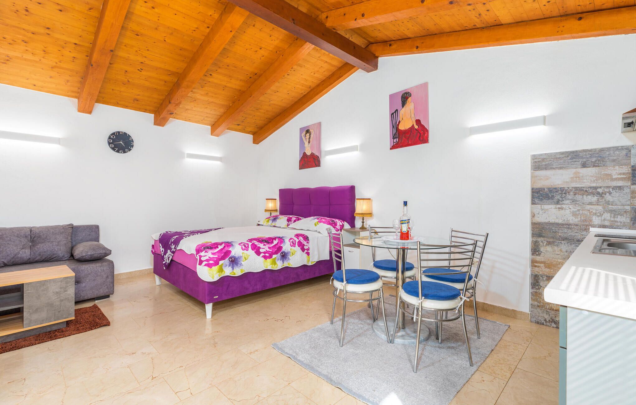 Une chambre comprenant un lit, un canapé, une table à manger avec des chaises et un coin cuisine.