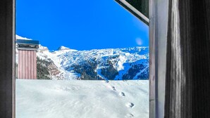 Un paysage de montagne enneigé, sous un ciel bleu dégagé.