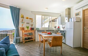 Une cuisine compacte avec un coin repas, un plancher en bois et une vue sur la mer.