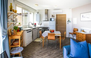 A compact kitchen with a dining area, a small refrigerator, and a microwave.