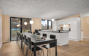 Enjoy meals in the kitchen with a central island and sink, and dine at the long table with pendant lighting.