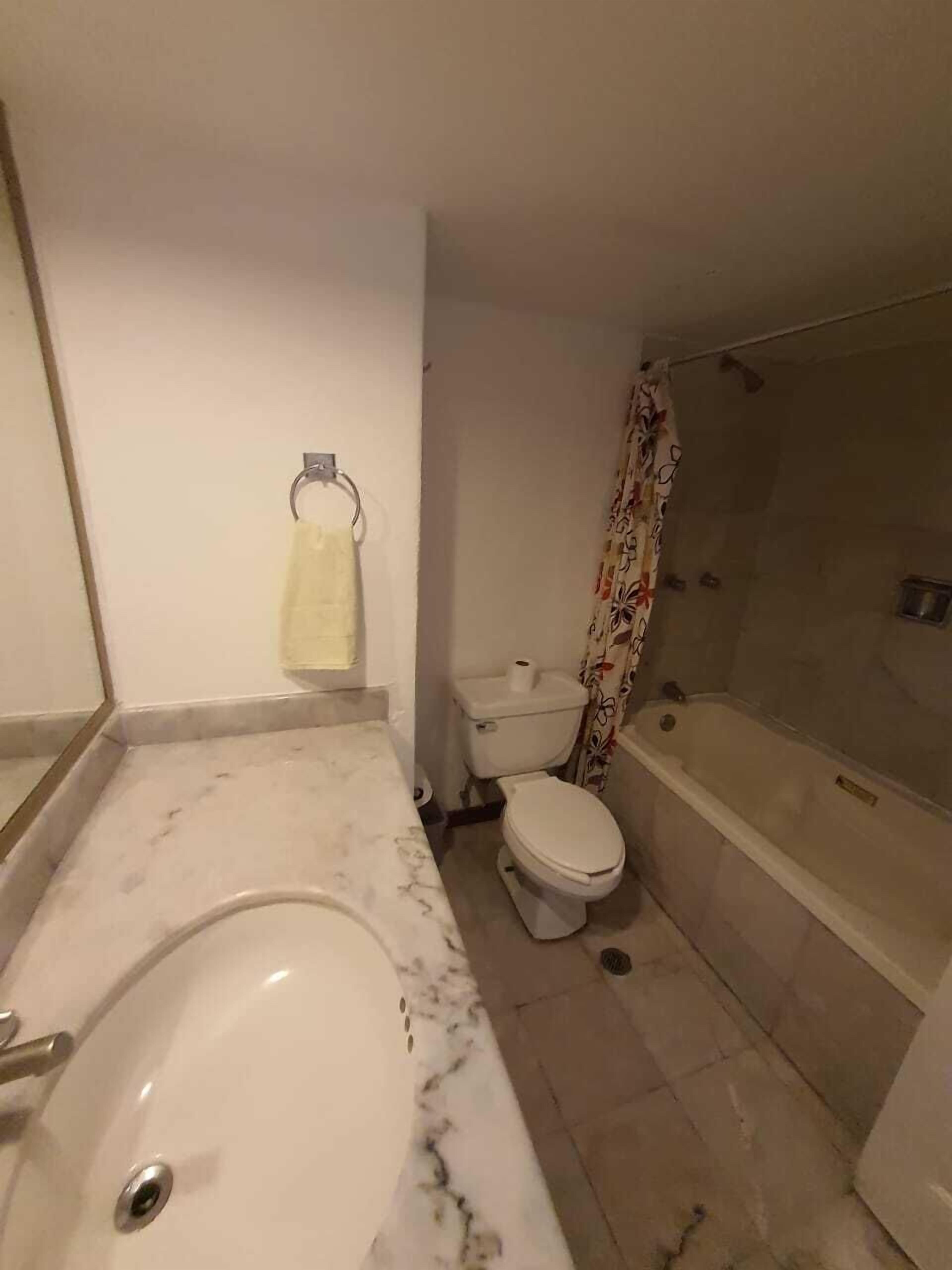 A bathroom with a bathtub, toilet, and shower.