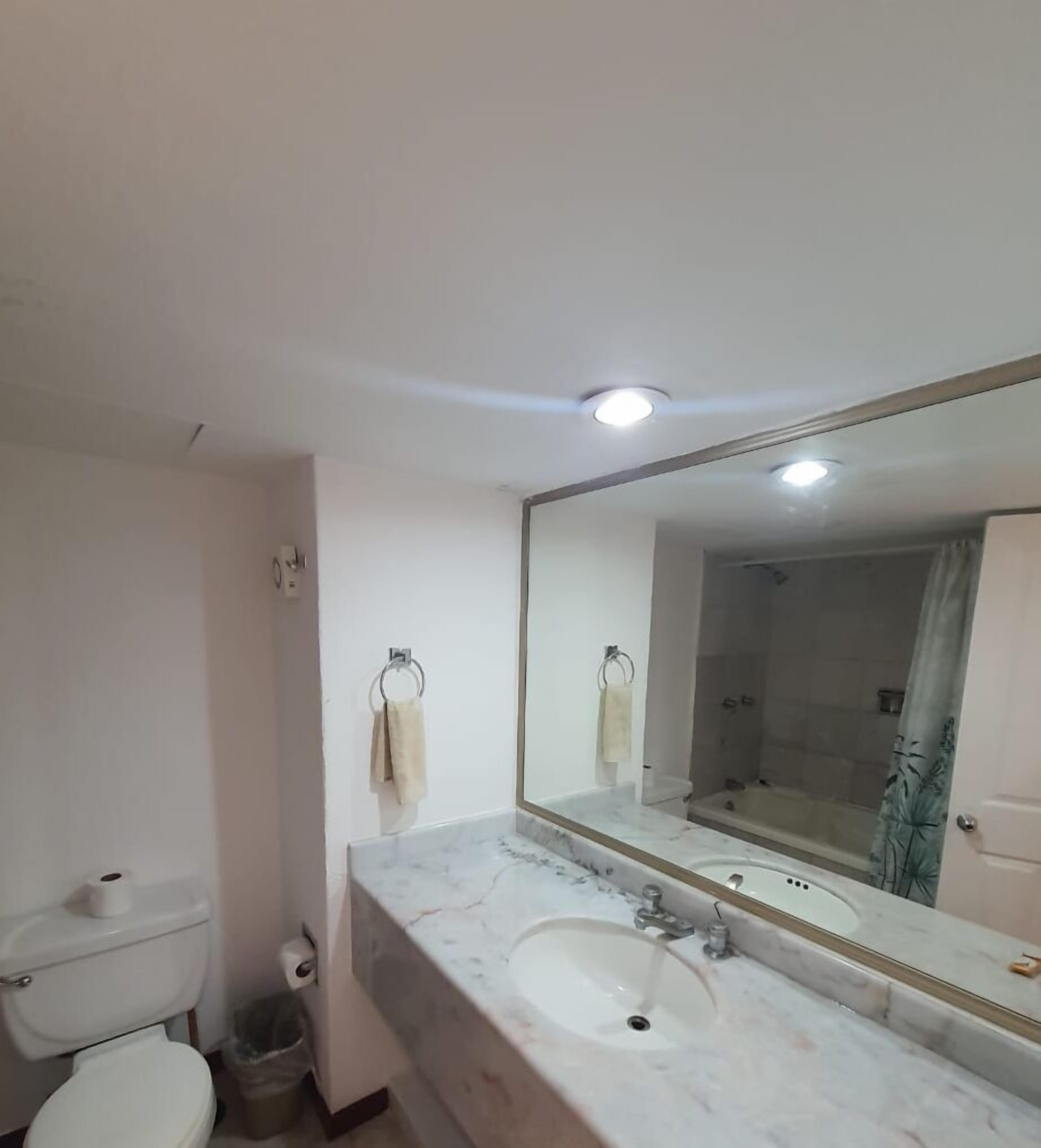 Ein Badezimmer mit Toilette, Waschbecken und Spiegel.