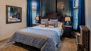 A bedroom with a large bed, two bedside tables, a mirror, and a nightstand. - Grand View · Madison Place (Apt #1) Grand View (Ogden)