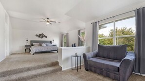 A bedroom with a bed, a nightstand, a ceiling fan, and a window with curtains. - Contemporary home in the heart of McKinney (McKinney)