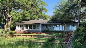 A single-story house with a covered porch and a well-maintained lawn. - MCM Magic on the Marsh (Mount Pleasant)