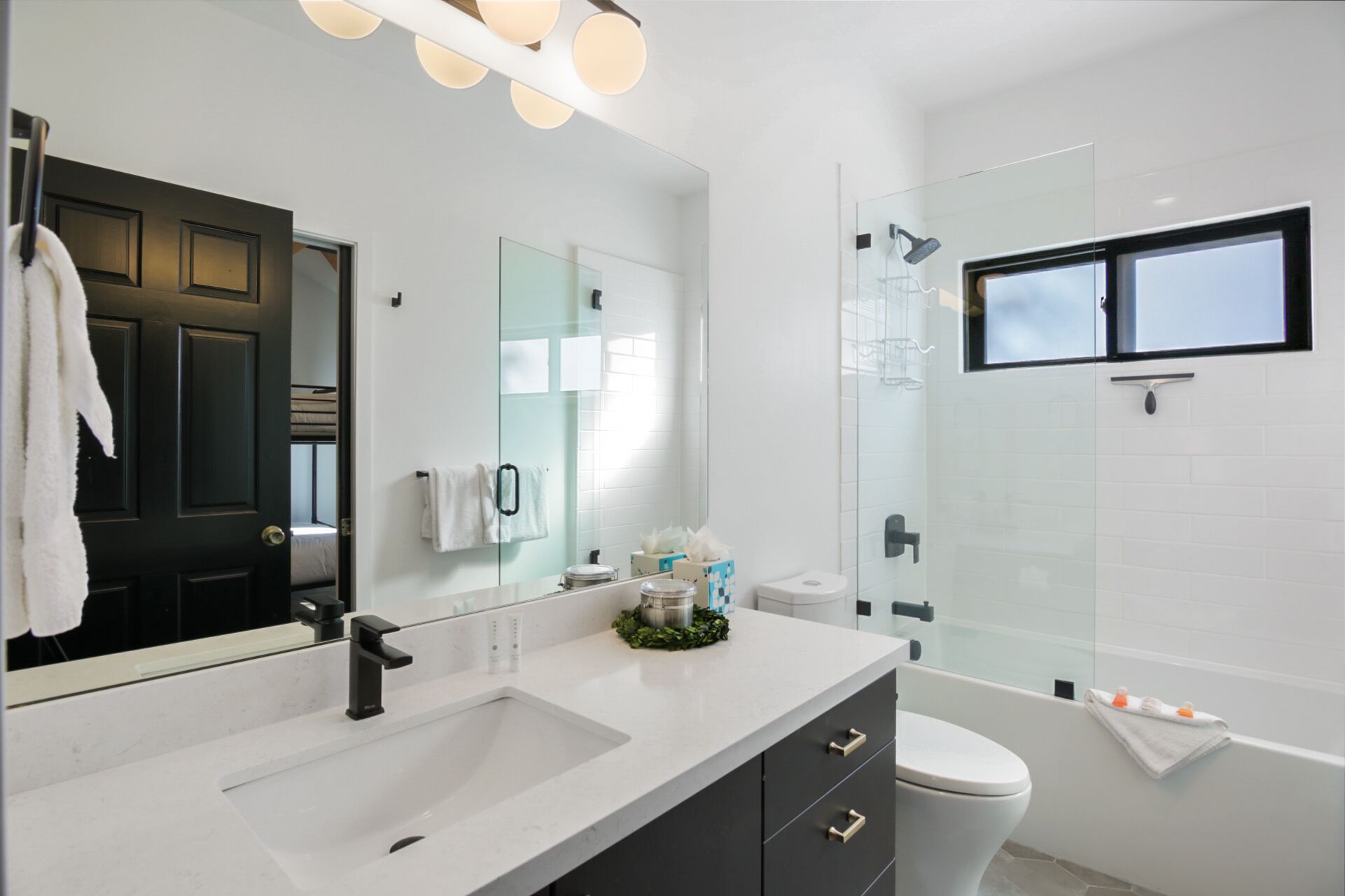 Un baño moderno con lavabo doble, inodoro y cabina de ducha de vidrio.
