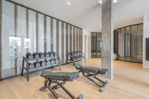 A gym with exercise equipment, including dumbbells and a bench.