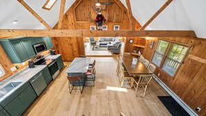 A spacious kitchen with modern appliances, a dining area with a large table, and a cozy living space with a fireplace.