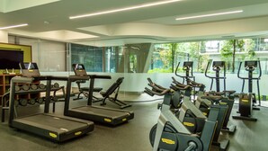 A modern gym with treadmills, elliptical machines, and weight machines.