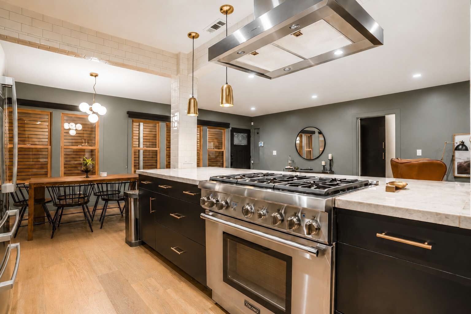 Una cucina moderna con isola centrale, elettrodomestici in acciaio inossidabile e illuminazione a sospensione.