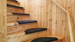 Ein Holzinnenraum mit einer Holztreppe und einem Metallgeländer.