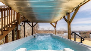 A hot tub with a wooden deck and a metal roof, overlooking a body of water. - Lake Front Mountain View w/ 6 King beds (Gainesville)