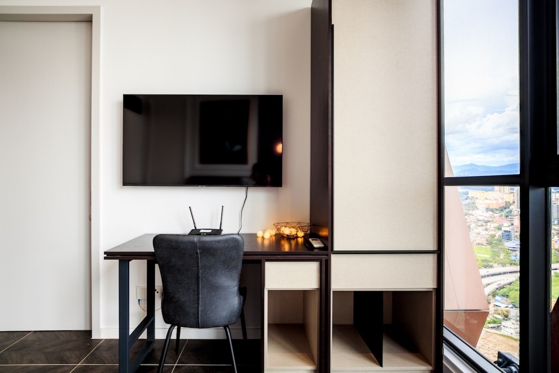 A modern office space with a desk, chair, and a mounted flat-screen TV.